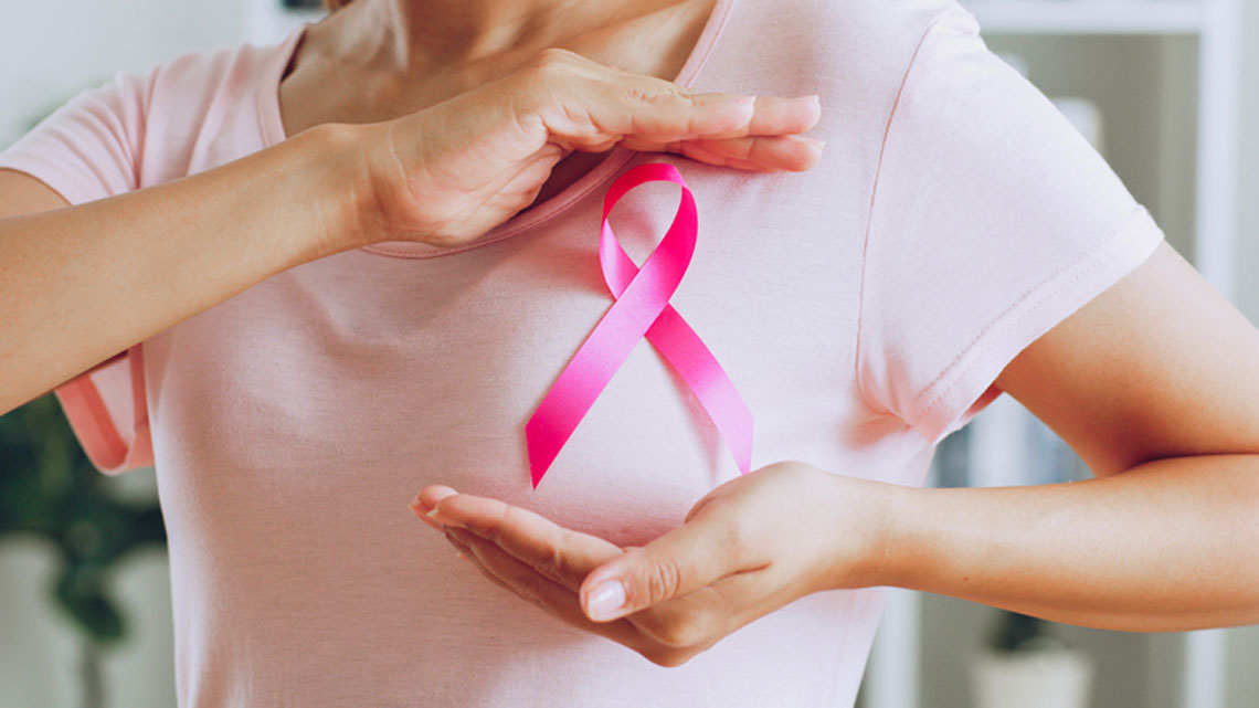 Mujer con un lazo rosa sobe el pecho por el Día Mundial contra el Cáncer de Mama