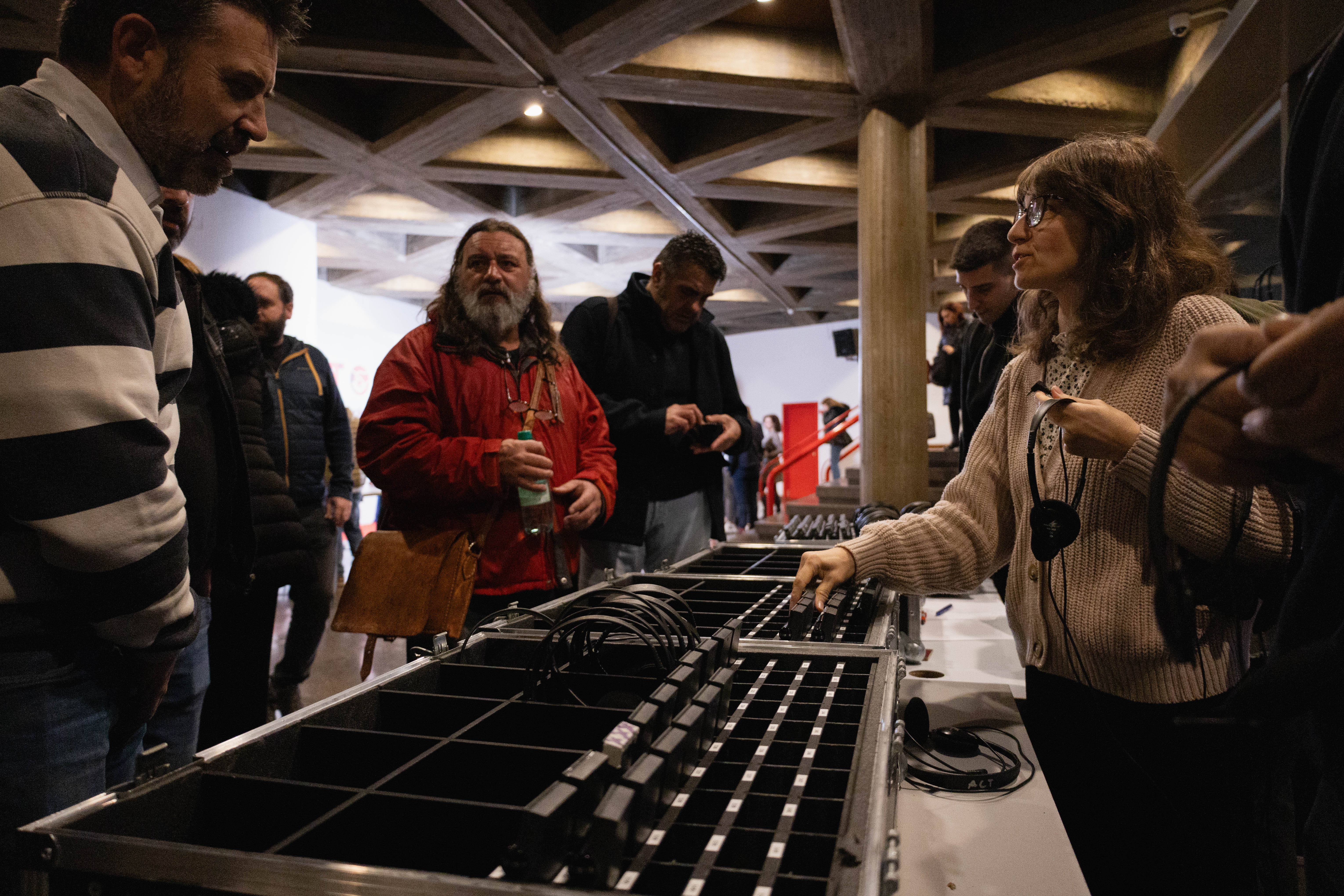 Los asistentes reciben los auriculares al inicio de la tercera jornada